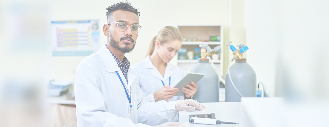 Une jeune femme et un homme, portant des blouses blanches, font un contrôle d’entretien de bouteilles de gaz.